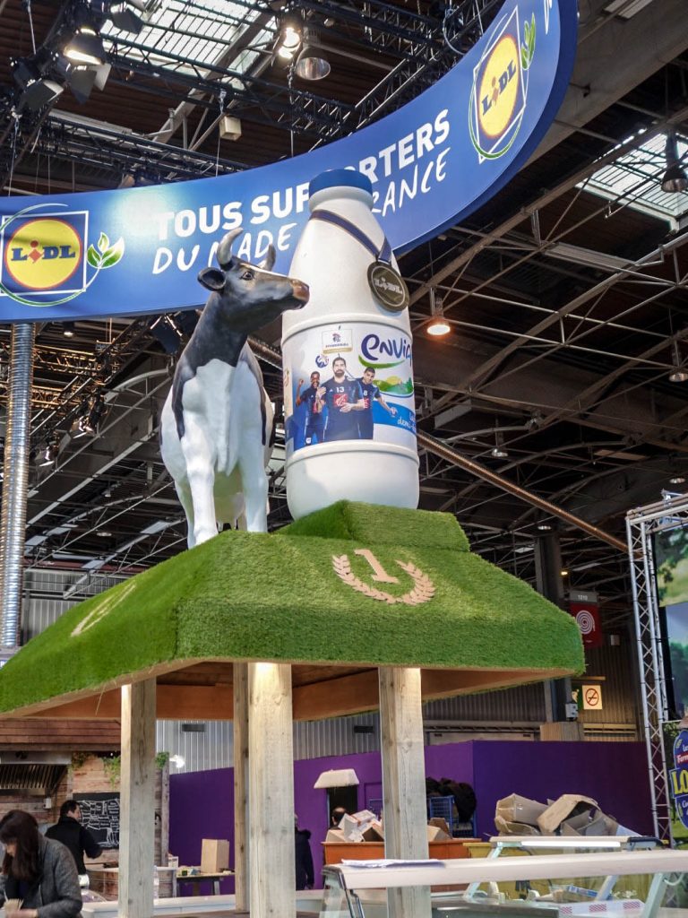 Conception de la scénographie pour Hopscotch de 2 stands pour Lidl au Salon de l'Agriculture de Paris. Le premier d'une surface de 300 m2 situé dans le hall 1 montrant les produits de la viande et du lait. Le second de 180 m2 dédié aux vins, fruits et légumes. La scénographie des stands est basé sur la thématique fournie qui est "Tous supporters du made in France". D'où le concept de "fermes" supportrices mêlant écharpes, médailles et podiums. Collaboration avec l'agence Hopscotch. Photos : Claude Lecante