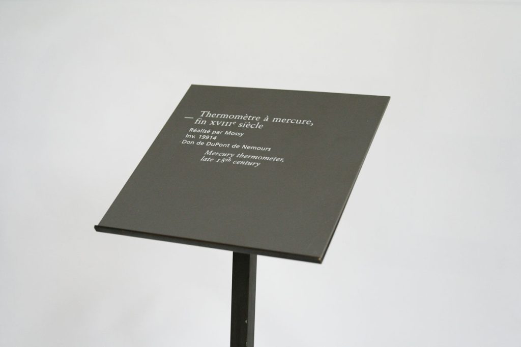 Assistance à Maîtrise d’Ouvrage pour l’ensemble de la signalétique. Mission de 4 mois sur site pour l’EPMOTC. Graphisme : Michel Bouvet Conception de supports en laiton pour les cartels présentés sur un socle (150 exemplaires réalisés). Étude pour la rénovation complète des deux modules d’entrée du musée. Recherche matériaux et nouveaux système d’éclairage. Plans et suivi de fabrication.