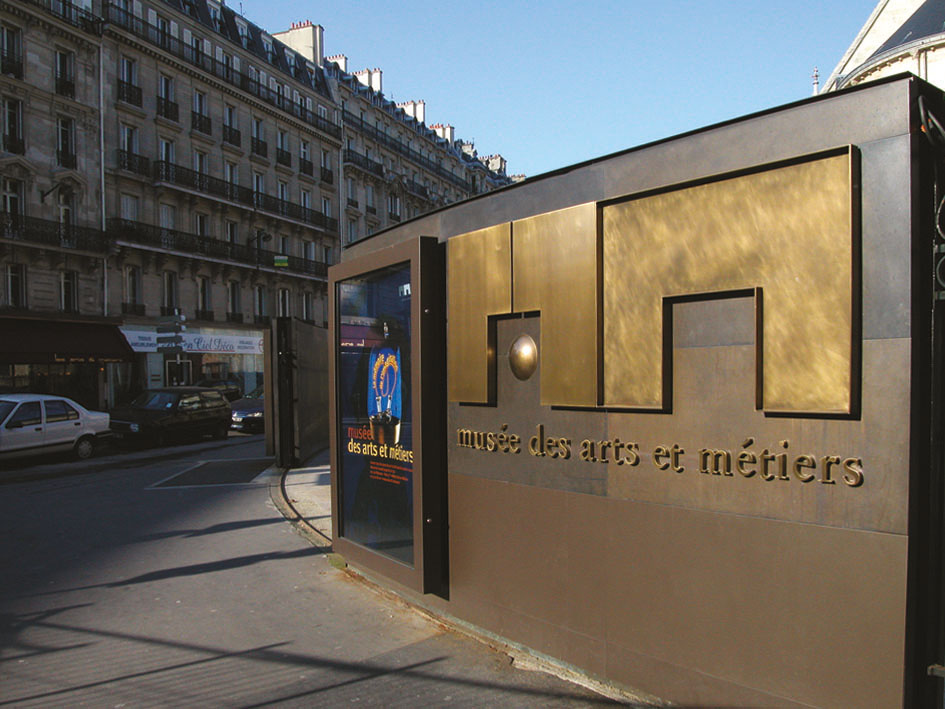 Assistance à Maîtrise d’Ouvrage pour l’ensemble 
de la signalétique. Mission de 4 mois sur site pour l’EPMOTC. 
Graphisme : Michel Bouvet 
Conception de supports en laiton pour les cartels présentés 
sur un socle (150 exemplaires réalisés).
Étude pour la rénovation complète des deux modules d’entrée 
du musée. 
Recherche matériaux et nouveaux système d’éclairage. 
Plans et suivi de fabrication.